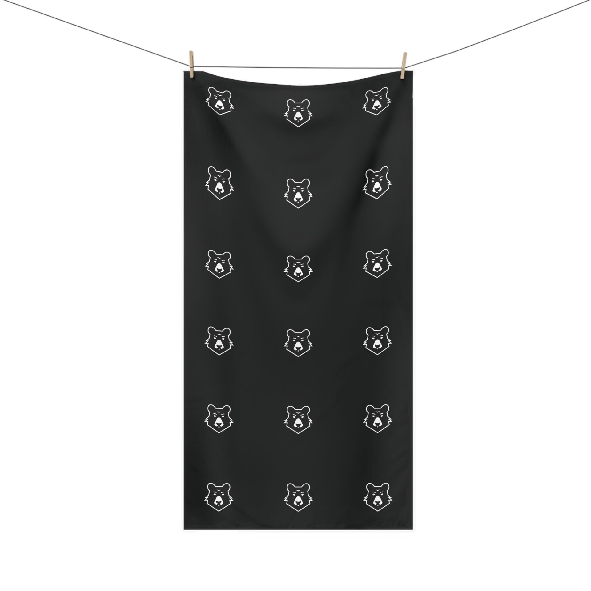 Black towel hanging on a clothesline, featuring a repeating pattern of white bear faces.